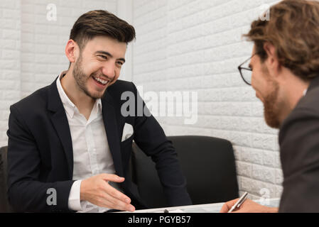 Two businessmen are negotiating a trade agreement together. Business and meeting concept. Job and occupation interview theme. Stock Photo