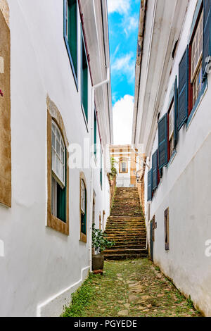 Old cobblestone street with houses in colonial architecture in the famous city of Ouro Preto in Minas Gerais Stock Photo