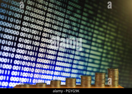 secured internet business. big coin piles in front of blue binary code computer screen. rich through savings account online. Stock Photo