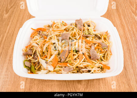Asian noodles with pork and vegetables in take away box. Stock Photo