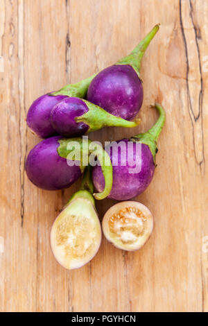 Organic Raw Baby Eggplants on wooden table from above. Stock Photo