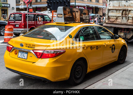 New York City, USA - June 22, 2018: Yellow taxi cab parked in the street bridge in Manhattan Stock Photo