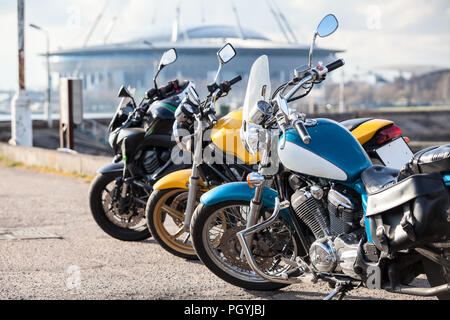 Motorcycles two wheels vehicles standing on parking lot: blue, yellow and black colors Stock Photo