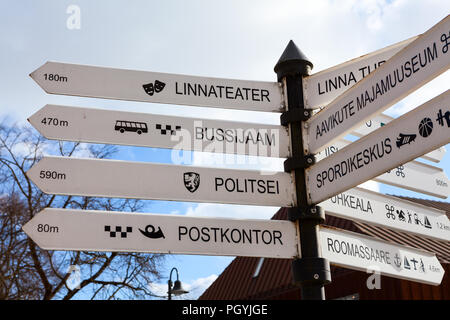 KURESSAARE, ESTONIA - CIRCA MAR, 2018: Direction plates on Estonian language are on finger-post on city street. Ways to theater, police, bus station a Stock Photo