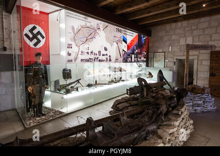 KURESSAARE, ESTONIA - CIRCA MAR, 2018: German soldier with Nazi flag and Soviet weapons and rarities. The exhibition tries to display the activities o Stock Photo