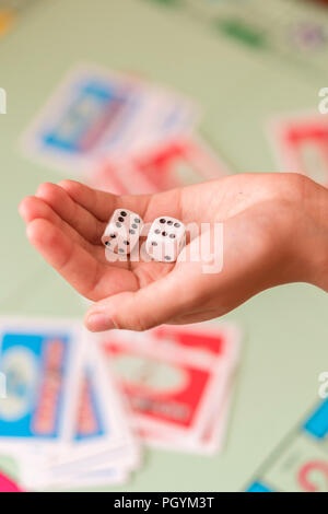 The hand throws game dice on the background of the playing field. vertical photo. Stock Photo