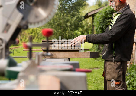 Senior men preparing wood materials with rotary saw Stock Photo