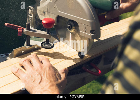 Senior men preparing wood materials with rotary saw Stock Photo
