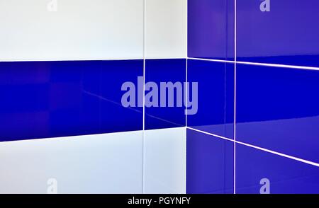 Blue and white gloss tiles with white joints in bathroom corner. Stock Photo