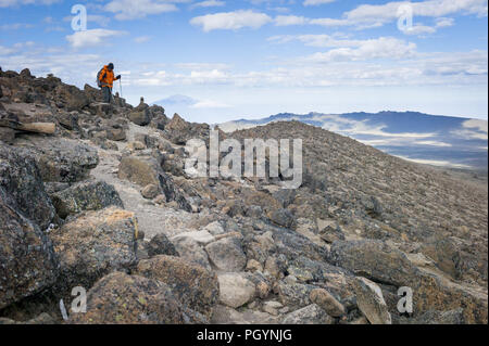 Hiker on northern circuit, with Mount Meru in the background, Mount Kilimanjaro, Kilimanjaro Region, Tanzania. Stock Photo