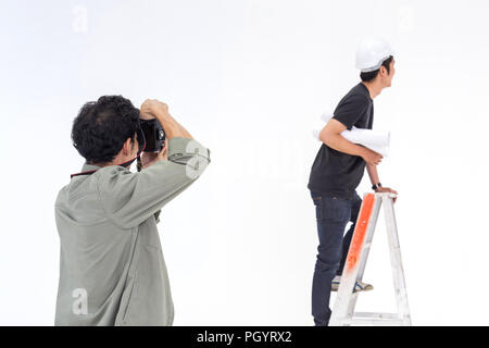 asian photographer is shooting a young man model in asian engineer concept in the studio for the stock photo. Stock Photo