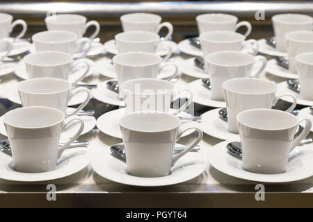 row of coffee and tea ceramic white cup preparing to serve on the business conference in front of the meeting room at the hotel. Stock Photo