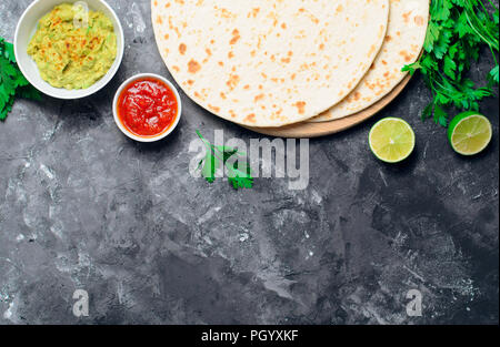Plain Tortillas with Tomato Salsa, Guacamole and Fresh Parsley on Dark Background, Delicious Wheat Tortillas, Mexican Food Stock Photo