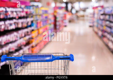 Shopping cart view in Supermarket aisle with product shelves abstract blur defocused background Stock Photo