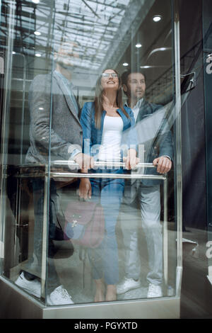 Business people in a large glass elevator in a modern office Stock Photo