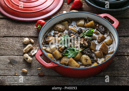 Famous thai dish massaman curry in red pan Stock Photo