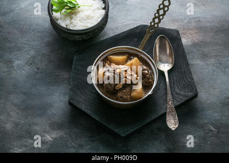Thai Beef Massaman Curry with Rice, dark background copy space Stock Photo