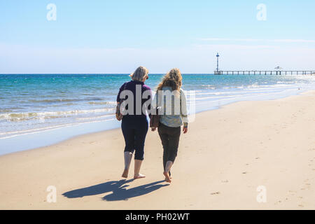 Adelaide Australia. 29 August 2018. Women stroll along the beach in the sunshine  on a warm sunny afternoon in the coastal suburb of Brighton Adelaide. Adelaide is experiencing warmer temperatures  on the final stages of the Australian winter season and the onset of spring Credit: amer ghazzal/Alamy Live News Stock Photo