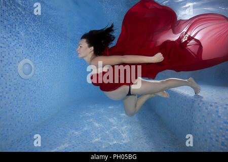 Odessa, Ukraine. 27th Aug, 2018. Pregnant woman in a red dress dives underwater in the pool Credit: Andrey Nekrasov/ZUMA Wire/Alamy Live News Stock Photo