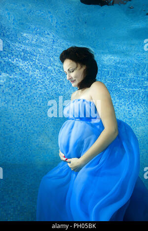 Odessa, Ukraine. 27th Aug, 2018. Pregnant woman in a blue dress posing underwater in the pool Credit: Andrey Nekrasov/ZUMA Wire/Alamy Live News Stock Photo