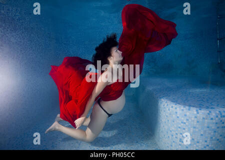 Odessa, Ukraine. 27th Aug, 2018. Pregnant woman in a red dress posing underwater in the pool Credit: Andrey Nekrasov/ZUMA Wire/Alamy Live News Stock Photo