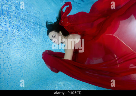 Odessa, Ukraine. 27th Aug, 2018. Pregnant woman in a red dress dives underwater in the pool Credit: Andrey Nekrasov/ZUMA Wire/Alamy Live News Stock Photo