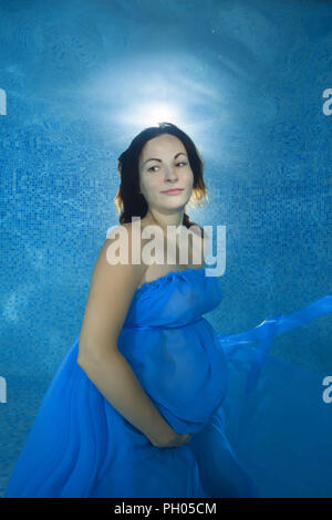 Odessa, Ukraine. 27th Aug, 2018. Pregnant woman in a blue dress posing underwater in the pool Credit: Andrey Nekrasov/ZUMA Wire/Alamy Live News Stock Photo