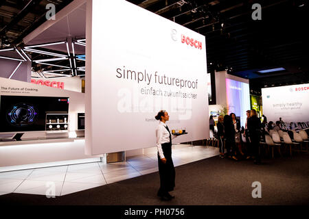 Berlin, Germany. 29th August 2018. Germany, Berlin. 29th Aug, 2018. A waitress carries a tray with drinks at the Bosch stand at the IFA electronics trade fair. The 'Consumer Electronics Unlimited' IFA is the world's largest trade fair in this field and will take place from 31 August to 5 September 2018. Credit: Carsten Koall/dpa/Alamy Live News Credit: dpa picture alliance/Alamy Live News Stock Photo