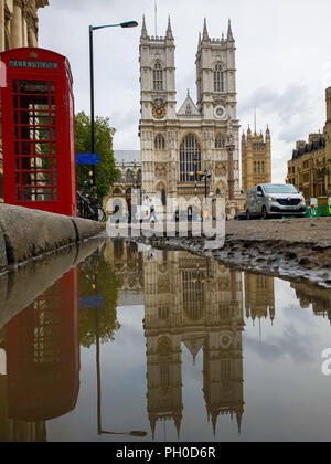 Westminster. London. UK 29 Aug 2018 - Reflection of a red telephone box and Westminster Abbey in puddle of water after early morning rainfall in central London.  Credit: Dinendra Haria/Alamy Live News Stock Photo