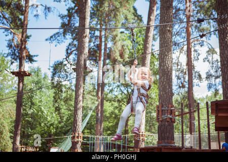 Little girl enjoying activity in a climbing adventure park. Stock Photo