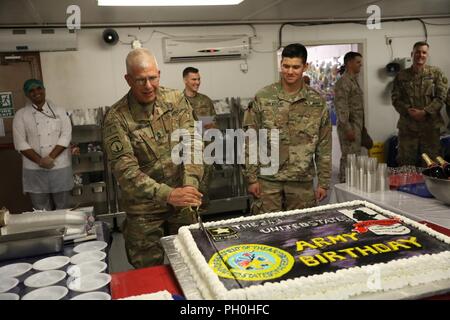 U.S. Army Master Sgt. Jeffrey Laws of Combined Joint Task Force – Operation Inherent Resolve, cuts a cake during the U.S. Army’s 243rd birthday ceremony, June 14, 2018, Union III, Baghdad, Iraq. The Army was established June 14, 1775, more than a year before the signing of the Declaration of Independence. Laws is the oldest soldier at Union III. Stock Photo