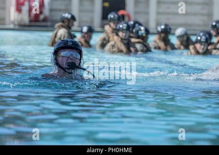 Pfc. Samuel Martens, machine gunner, Kilo Company, 3rd Battalion, 5th Marine Regiment, surfaces after successfully escaping from the Modular Amphibious Egress Trainer (MAET) during underwater egress training on Marine Corps Base Camp Pendleton, Calif., June 14, 2018. Marines went through the training to gain the skills and mindset needed to safely exit a sinking aircraft in a real-life situation. Stock Photo