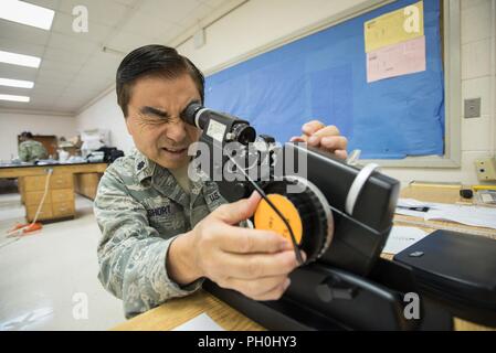 U.S. Air Force Lt. Col. Ronald Short, an optometrist with the California Air National Guard’s 163rd Attack Wing, tests optometry equipment for a health-care clinic at Lee County High School in Beattyville, Ky., June 14, 2018. The clinic is one of four being staffed by military health-care professionals in Eastern Kentucky from June 15 to June 24 as part of an Innovative Readiness Training mission called Operation Bobcat. The mission provides military forces with crucial expeditionary training while offering no-cost medical, dental and optometry care to area residents. Stock Photo