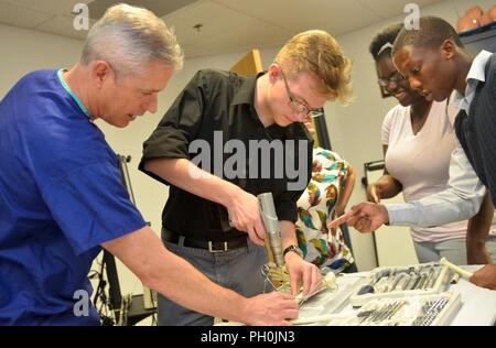 JACKSONVILLE, Fla. (June 14, 2017) – Darnell-Cookman School of the Medical  Arts student Kayla Richemond dons surgical gloves and gown in an operating  suite as part of Naval Hospital Jacksonville's Science, Service