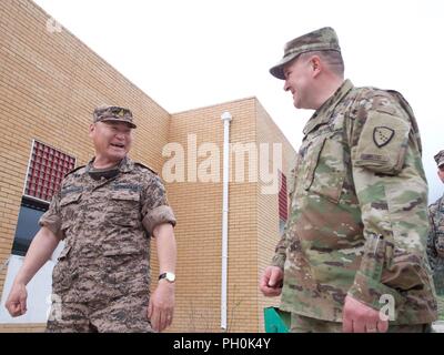 Mongolian Armed Forces Brig. Gen. L. Ganselem, exercise co-director for Khaan Quest 2018, and Alaska Army National Guard Col. Peter Mondelli, 297th Regional Support Group commander and Khaan Quest 18 exercise director, share a laugh June 15, 2018, while inspecting training at the Peacekeepers Resort, Mongolia. Khaan Quest 2018 is a regularly scheduled, multinational exercise co-sponsored by U.S. Pacific Command and hosted annually by the Mongolian Armed Forces. KQ18 is the latest in a continuing series of exercises designed to promote regional peace and security. This year’s exercise marks the Stock Photo