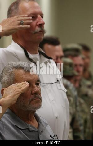 Former members of the 1st Battalion, 160th Field Artillery Regiment, 45th Infantry Brigade Combat Team salute alongside current Soldiers for the playing of the national anthem during a ceremony marking the reactivation of the battalion's Charlie Battery at the Armed Forces Reserve Center on Fort Sill, Oklahoma, June 17. Stock Photo