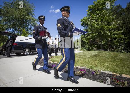 U.S. Army Sgt. Bless Sherrill, right, and Sgt. Raheem Rowell, both with the New Jersey Army National Guard, carry a flag and an urn containing the cremains of a veteran during the 28th New Jersey Mission of Honor (NJMOH) ceremony at the Brigadier General William C. Doyle Veterans Memorial Cemetery at North Hanover Township, N.J., June 14, 2018. The cremains of seven World War II veterans Geoffrey N. Barrow, Henry Brandon and wife, Willa Mae; Arthur R. Callan, James Grant Sr., Theodore R. Jackson Jr., Monroe E. Morris, and Charlie Waters; two Vietnam veterans Johnny W. Morgan and Gilbert J. She Stock Photo