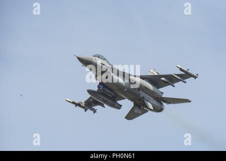 F-16 Fighting Falcons from the 120th Fighter Squadron, Colorado Air National Guard, fly over Adazi Range for a show of force after dropping live bombs there, during the Saber Strike 18 exercise, June 15, 2018 . Saber Strike 18 is the eighth iteration of the long-standing U.S. Army Europe-led cooperative training exercise designed to enhance interoperability among allies and regional partners, while focusing on improving land and air operational capabilities and train with NATO's enhanced Forward Presence (eFP) battlegroups. Stock Photo