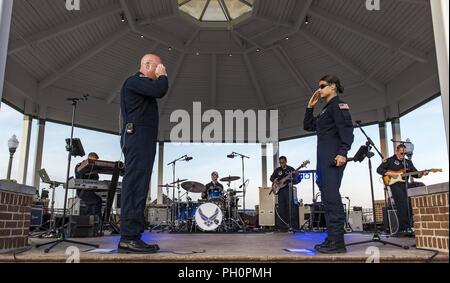 Senior Master Sgt. Ryan Carson, Max Impact superintendent and vocalist, and Tech. Sgt. Nalani Quintello, Max Impact vocalist, salute each other June 16, 2018, on the bandstand at Rehoboth Beach, Del. Max Impact, the premier rock band of the U.S. Air Force, is stationed at Joint Base Anacostia-Bolling in Washington, D.C. Stock Photo