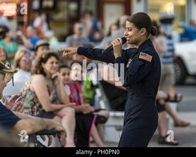 Tech. Sgt. Nalani Quintello, Max Impact vocalist, performs for hundreds of beachgoers June 16, 2018, on the bandstand at the Rehoboth Beach, Del. Quintello was a former contestant on the television show, “American Idol;” she withdrew from the competition to serve in the Air Force. Max Impact, the premier rock band of the U.S. Air Force, is stationed at Joint Base Anacostia-Bolling in Washington, D.C. Stock Photo