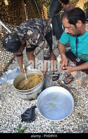 Soldiers from the United Arab Emirates prepare a traditional Emirate meal of machboos, which is a rice dish with chicken, to share with Ohio National Guard and Serbian Armed Forces personnel, June 19, 2018 at Serbia’s South Base and Boravac Training Area, during Exercise Platinum Wolf 2018. The goal of the meal was to ensure the soldiers’ religious dietary needs were properly met and share ideas for continued religious support of the Emirate soldiers in the future. Platinum Wolf 18, a two-week multinational peacekeeping exercise, brings 10 nations together to enhance military cooperation and i Stock Photo