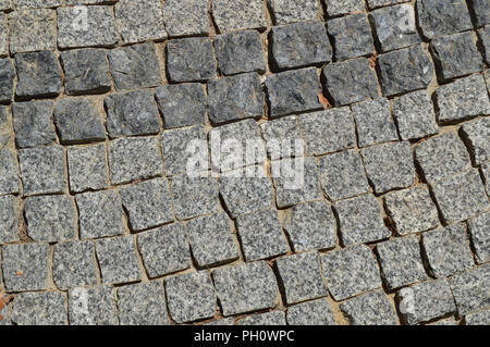 Background square gray granite stones lined the path on the pavement. Stock Photo