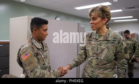 HONOLULU, Hawaii (June 21, 2018) -- The Army Surgeon General and U.S. Army Medical Command (MEDCOM) Commanding General, Lt. Gen. Nadja West, presents a coin to Staff Sgt. Gaurav Bhattarai, Dental Health Command-Pacific (DHC-P) Soldier during a visit to the DHC-P headquarters. Stock Photo