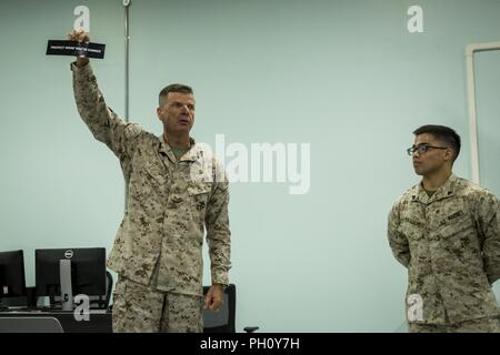 UNDISCLOSED LOCATION, MIDDLE EAST – U.S. Marine Corps Lt. Gen. William D. Beydler, commander of the U.S. Marine Corps Forces Central Command, awards a bumper sticker to Cpl. Noah A. Pascual (right), a maintenance management specialist with Combat Logistics Detachment 37, during a town hall meeting with Special Purpose Marine Air-Ground Task Force, Crisis Response-Central Command June 22, 2018. During his visit, Beydler recognized five Marines for excellence in their duties and encouraged Marines to “protect what they’ve earned.” Stock Photo