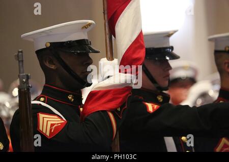 The 38th Color Sergeant of the Marine Corps, Sgt. Francis Frazier, carries the National Ensign during a Friday Evening Parade at Marine Barracks Washington D.C., June 22, 2018. The guest of honor for the ceremony was the Secretary of the Navy, Richard V. Spencer, and the hosting official was the Commandant of the Marine Corps, Gen. Robert B. Neller. Stock Photo