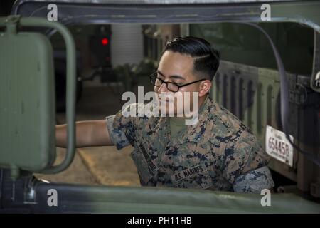 Cpl. Jose Dominguezcruz, a motor transportation operator with Motor Transportation and Maintenance Company, Headquarters Regiment, 3rd Marine Logistics Group, teaches a Humvee course on Camp Kinser, Okinawa, Japan, June 26, 2018. MTM Company conducts regular training for different driving courses including Humvee, government vehicle and assistant driver courses. Dominguezcruz is a native of Santa Maria, California. Stock Photo