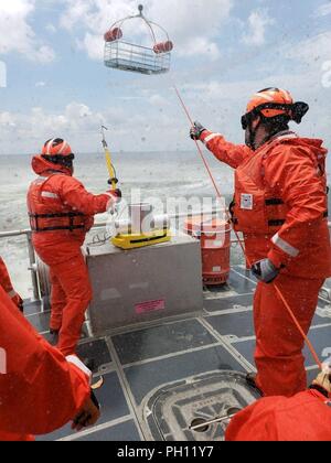 Coast Guard Station St. Petersburg crewmembers and Immigration and Customs Enforcement Rapid Response Team members conduct rescue helicopter operations aboard a 45-foot Response Boat-Medium in St. Petersburg, Florida, June 21, 2018. Station St. Petersburg crewmembers spent four days teaching the special agents seamanship skills, boat handling, and man-overboard response techniques. Stock Photo