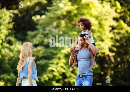 Portrait of young father carrying his daughter on his back Stock Photo