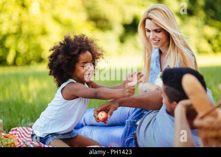 Picture of lovely couple with their daughter having picnic Stock Photo