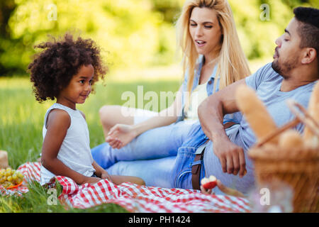 Picture of lovely couple with their daughter having picnic Stock Photo